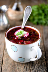 Traditional Ukrainian soup borsch on an old wooden background. Rustic style.