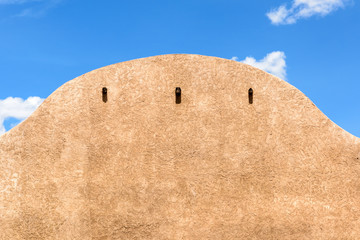 Close-up of an adobe building with a blue sky above