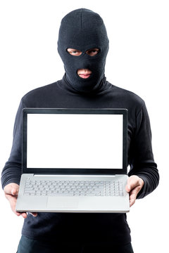 Hacker in a mask with a laptop, space for writing on the laptop's screen