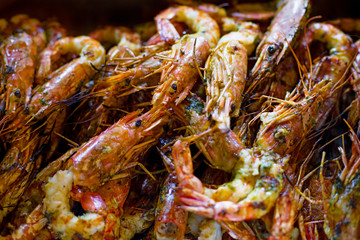 Royal prawns, seafood on the grill on the stove, on the street food market. Shrimp as background.
