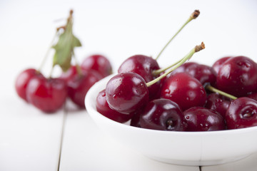 Cherries in a white plate on a white background