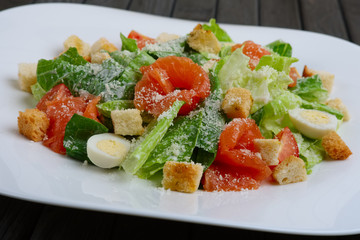 Close up photo of salad with quail egg, salmon and vegetables