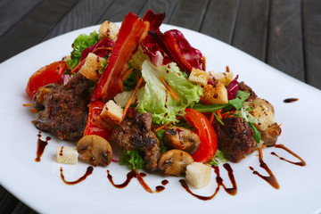 Salad with liver, bacon, grilled tomato and pepper with red cabbage and mushrooms