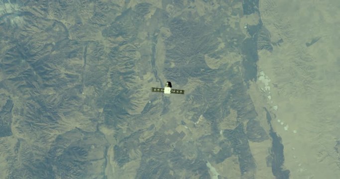 Satellite in outer space flies over Earth landscape