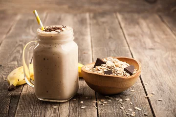 Cercles muraux Milk-shake Smoothie au chocolat à la banane et muesli sur table en bois