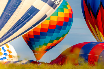 Obraz premium Colorful hot air balloons flying in the blue sky. The first minute after takeoff. Balloon Festival — The Golden Ring Of Russia — Pereslavl Zalesskiy.