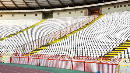 A white seat and a fence with a spear to the stadium