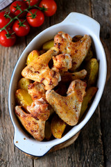 Chicken wings baked with potatoes in spices and aromatic herbs - basil, rosemary, dill and garlic.