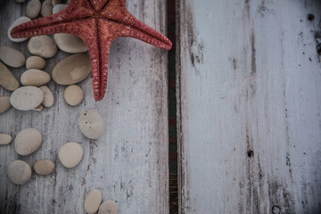 White pebbles minimalistic composition with starfish /  Rustic wooden background