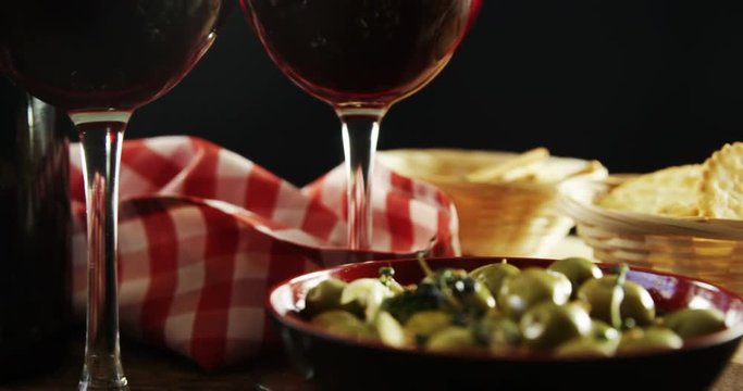 Red wine and green olive tapas on table
