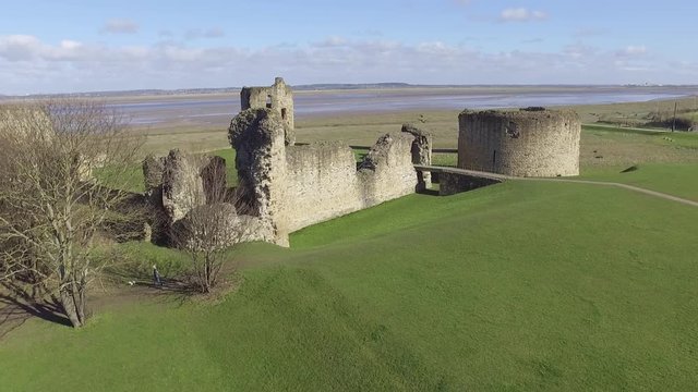 Aerial footage flying over Flint Castle with flyby close to Castle turret.