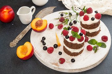 Chocolate cake decorated with raspberry, black currant, nectarine, wipped cream and mint.