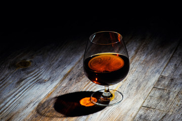 glass with cognac on a wooden background
