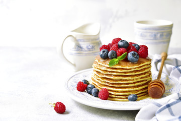 Homemade pancakes with honey and fresh berries.