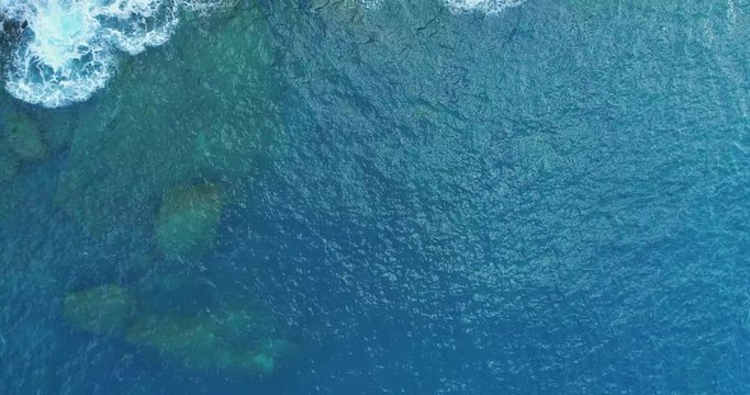 aerial overhead view of ocean mediterranean sea waves reaching and crashing on rocky shore beach coast. Sunny weather. 4k slow motion 60p top view drone video shot
