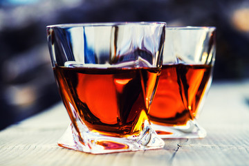 shot of whiskey at sunset dramatic sky on mountain landscape background