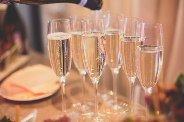 Line of different colored alcohol cocktails on a decorated catering banquet table on a party