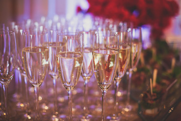 Line of different colored alcohol cocktails on a decorated catering banquet table on a party
