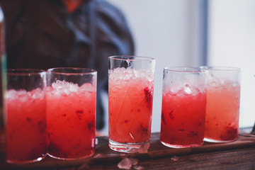 Line of different colored alcohol cocktails on a decorated catering banquet table on a party