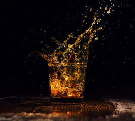 Isolated shot of whiskey with splash on black background
