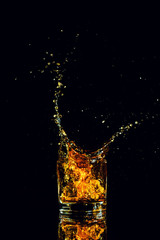 Isolated shot of whiskey with splash on black background