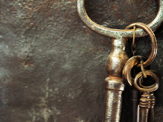 Bunch of ancient rusty keys of different sizes on vintage background of old and dark metal. Trinket keys