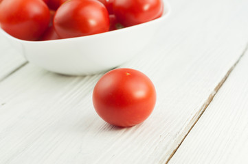 Single ripe tomato on old white wooden planks