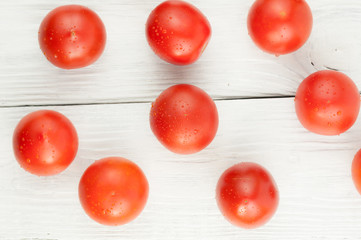 Fototapeta na wymiar Many fresh red and ripe tomatoes scattered on old white wooden planks