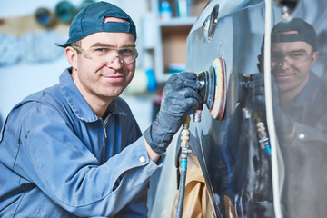 auto repairman grinding autobody bonnet