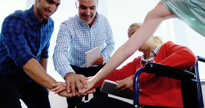 Team of business executives forming handstack