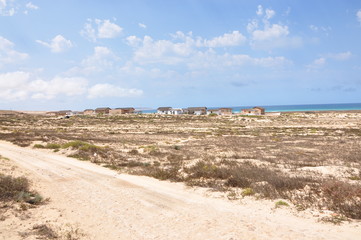 Route sableuse et maisons bord de mer Cap Vert