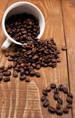 Overturned white cup with coffee beans
