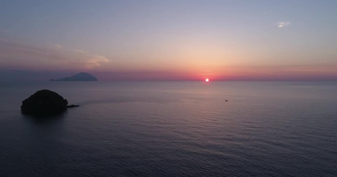 moving side aerial view of mediterranean sea ocean at sunset or sunrise with far islands. Nature outdoors travel establisher, Italy, Sicily Eolian Island. summer or spring.4k drone establishing video