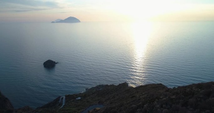discovering aerial view of mediterranean sea ocean at sunset or sunrise with far islands. Nature outdoors travel establisher, Italy, Sicily Eolian Island. summer or spring.4k drone establishing video