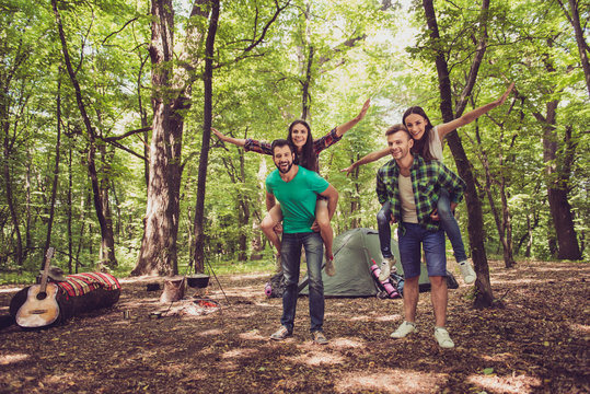 Chill, fun, joy, love and friendship! Four friends are fooling around in a wood at a campground, boys piggyback their ladies