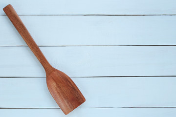 wooden ladle on blue wood background.
