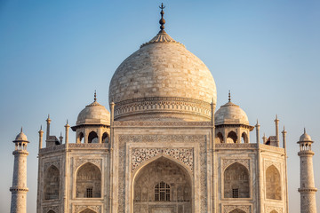 View of Taj Mahal with pool reflection in Agra India at sunrise.