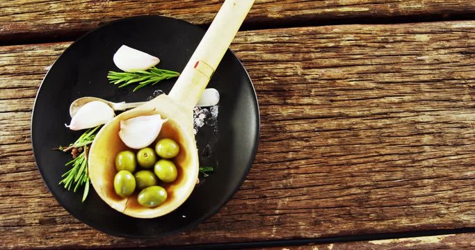 Ingredients olive and garlic kept on a black plate