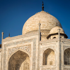 View of Taj Mahal with pool reflection in Agra India at sunrise.