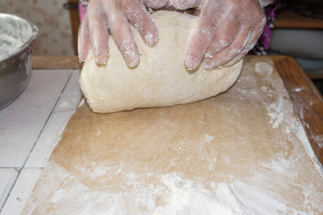 Top view shot of female hands mixing dough. Female hands knead dough on wooden board. 4k prores...