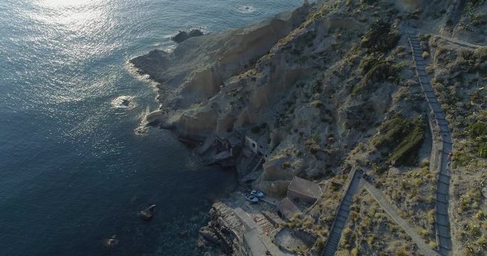 moving backward aerial view of mediterranean sea wild green rocky coast.Nature environment outdoors travel establisher,Italy,Sicily Salina Eolian Island.Sunny summer.4k drone establishing video