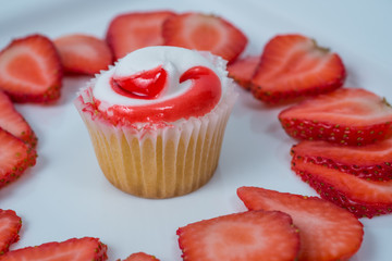 single cupcake with strawberry slices on white background
