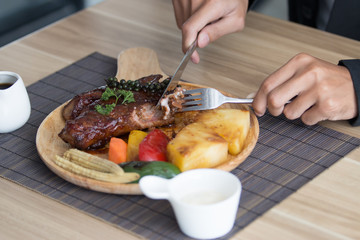 Businessman holding fork and knife eating steak, business and food/restaurant concept