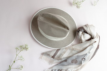 female accessories in pastel colors scarf, hat on light background. top view