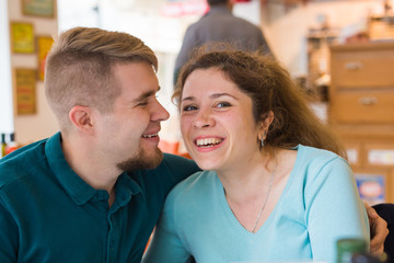 Portrait of laughing caucasian couple enjoying date in cafe