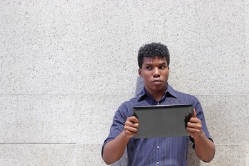 man holding tablet computer looking to his right with suspcious look