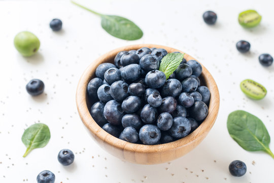 Blueberries in Wooden Bowl on white background. Fresh summer berry isolated