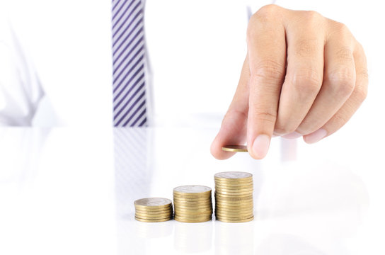 Business man with hand putting coins stack for financial ideas concept backgrounds