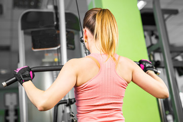 Fototapeta premium health, fitness, lifestyle, technology and people concept - Sportive young woman in a gym training. Working out in a sport club