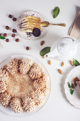 Decorated dessert table where the cake with meringue, layered pieces of cake. Arrangement of delicious sweets, top view